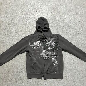 Grey and white zip-up hoodie with cross, wings, and flames design